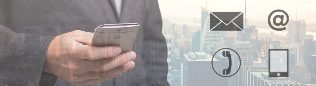 Person in suit holding phone with various contact method icons appearing next to them.
